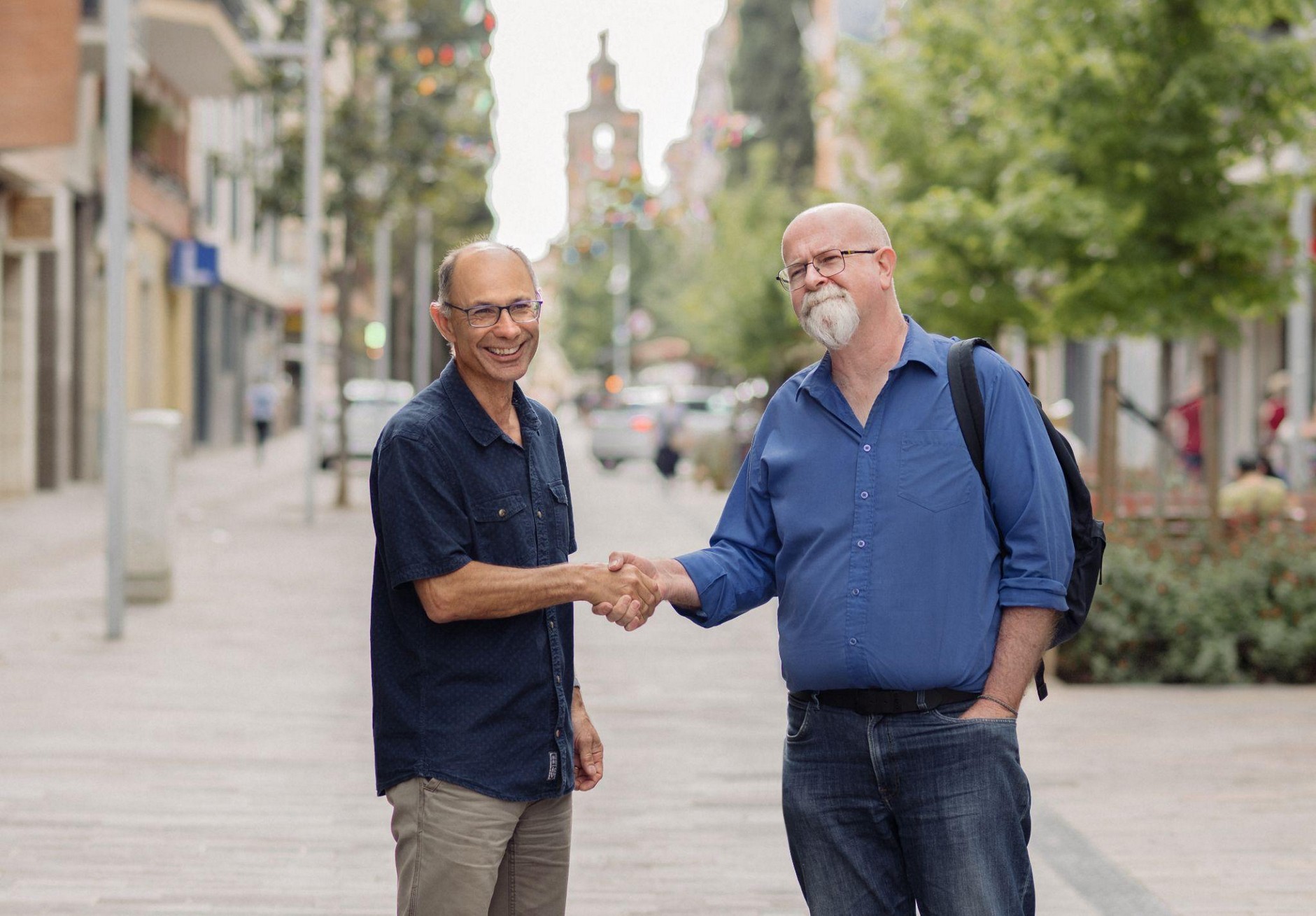 Aston Swift and Ian Gibbs shaking hands on a Sant Cugat street
